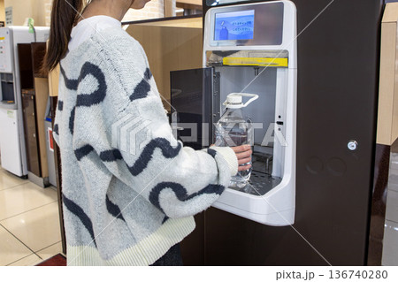 スーパーのウォーターサーバーで水を汲む女性 136740280