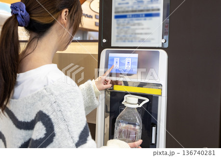 スーパーのウォーターサーバーで水を汲む女性 136740281