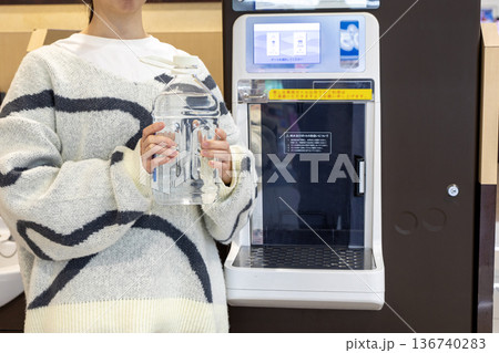 スーパーのウォーターサーバーで水を汲む女性 136740283