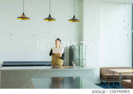 資料を見ながら現場を確認する空調服の職人の男性 資料を見ながら現場を確認する空調服の職人の男性 136740965