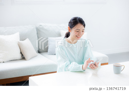 部屋でスマホを使う女性 136741719