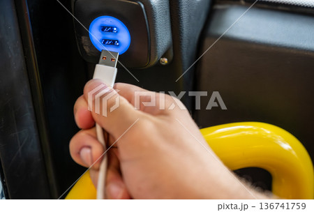 Berlin, germany, august 14, 2023. Hand plugging a data cable into a bus usb charger, powering devices and enabling connection for commuters on the go 136741759
