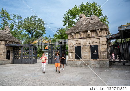 Berlin, germany, august 14,2023. Tourists entering berlin zoo through the historic lion gate or lowentor, a famous landmark and architectural entrance 136741832