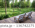 Luxury wooden terrace with lounge chairs overlooking a lush green forest 3d render 136742275