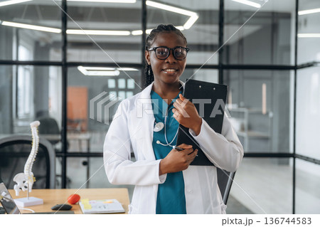 In white coat. Female doctor in coat is in the office clinic In white coat. Female doctor in coat is in the office clinic 136744583