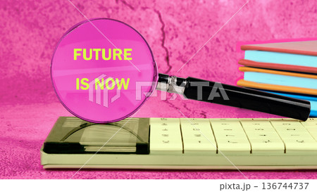 Future is Now magnified, near an antique calculator bright books on pink, urging action knowledge Future is Now magnified, near an antique calculator bright books on pink, urging action knowledge 136744737