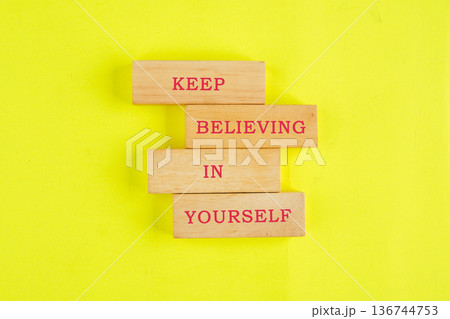 Warm wooden blocks display the encouraging phrase Keep Believing In Yourself on a bright, sunny yellow surface, radiating positivity and inspiration Warm wooden blocks display the encouraging phrase Keep Believing In Yourself on a bright, sunny yellow surface, radiating positivity and inspiration 136744753