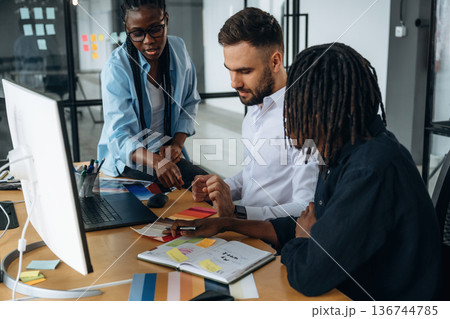 By the table together. Business people are working in the office 136744785