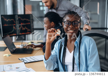 Crypto coin in hand of woman. Business people are working in the office 136744811
