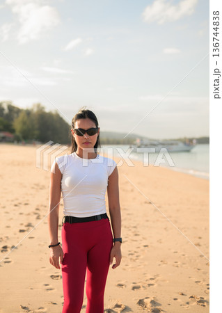 Fit Asian Woman in Sportswear Standing on Beach During Summer Workout Fit Asian Woman in Sportswear Standing on Beach During Summer Workout 136744838
