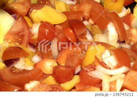 Close up of mixed fried vegetables chopped tomatoes, onions and peppers frying 136745211