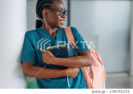 Smart woman student with pink backpack is indoors 136745255