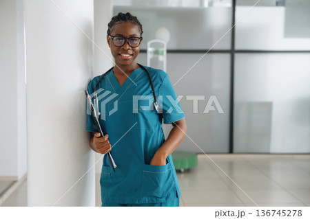 Front view, standing. Female doctor is indoors in modern room Front view, standing. Female doctor is indoors in modern room 136745278