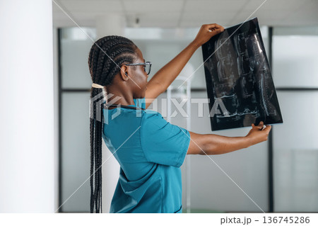 X-ray results. Female doctor is indoors in modern room 136745286