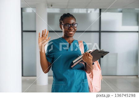 Smart woman student with pink backpack is indoors 136745298