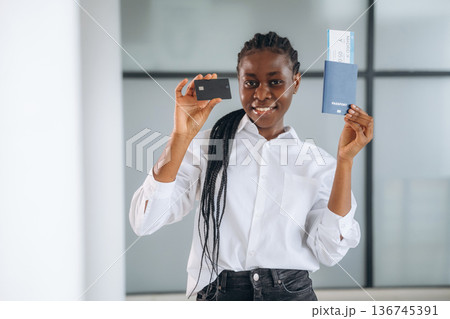 Vacation time, airport, with tickets. Businesswoman in formal clothes is in the modern room Vacation time, airport, with tickets. Businesswoman in formal clothes is in the modern room 136745391