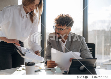 Teamwork conception. Man and woman are indoors in modern building 136745868