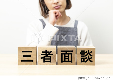 「三者面談」と書かれたブロックとエプロン姿の女性 「三者面談」と書かれたブロックとエプロン姿の女性 136746087