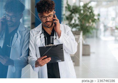Front view. Doctor is indoors in the modern building Front view. Doctor is indoors in the modern building 136746186