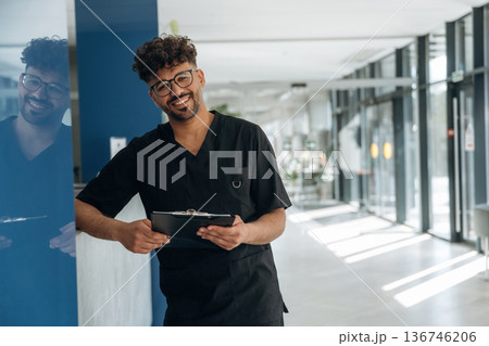 Male doctor is indoors in the modern building 136746206
