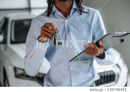 Close up view of man's hand that is holding keys in the auto salon 136746493