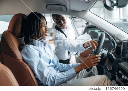 Testing the comfortable seats. Man and woman are in the automobile 136746600