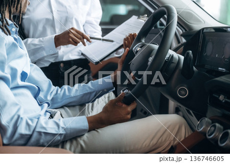 Trying the feel of vehicle. Man and woman are in the automobile 136746605