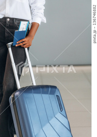 Woman is standing with suitcase, documents and airplane tickets Woman is standing with suitcase, documents and airplane tickets 136746882
