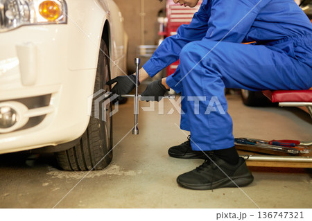 工場でタイヤ交換をする自動車整備士 136747321
