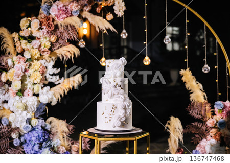 Elegant white wedding cake with floral decor at luxury reception celebration Elegant white wedding cake with floral decor at luxury reception celebration 136747468