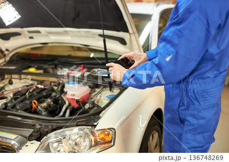 ボンネットの中をスマホで撮る自動車整備士 ボンネットの中をスマホで撮る自動車整備士 136748269