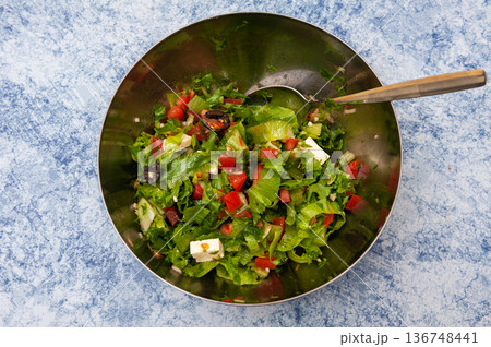 Salad of Iceberg Lettuce with Tomatoes, Olives, White Salad Cheese, Garlic and Olive Oil . 136748441