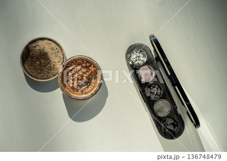 Broken eyeshadow palettes on a white table. Decorative cosmetics Broken eyeshadow palettes on a white table. Decorative cosmetics 136748479