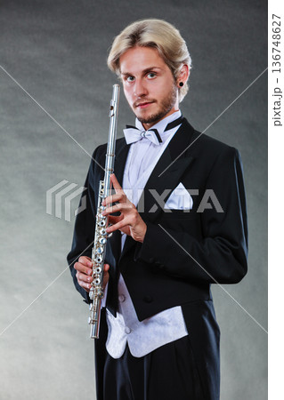 Elegantly dressed musician holding flute Elegantly dressed musician holding flute 136748627