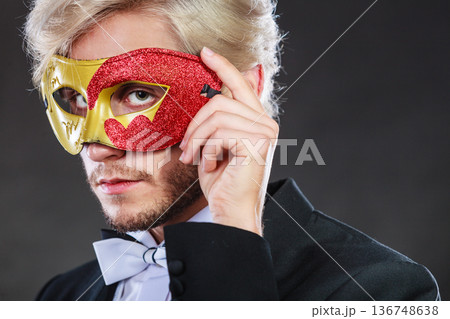 Young man in carnival mask on dark Young man in carnival mask on dark 136748638