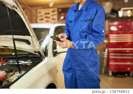 ボンネットの中をスマホで撮る自動車整備士 136748652