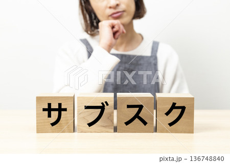 「サブスク」と書かれたブロックとエプロン姿の女性 136748840