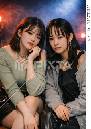 カジュアルなファッションに身を包んだ2人の日本人女性。夜の街をイメージしたクールなポートレート。 136751333