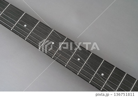 Close-up of a dark wooden guitar fretboard neck Close-up of a dark wooden guitar fretboard neck 136751811