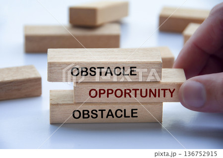 Obstacle and Opportunity text on wooden blocks symbolizing turning barriers into strategic opportunities for growth. Obstacle and Opportunity text on wooden blocks symbolizing turning barriers into strategic opportunities for growth. 136752915