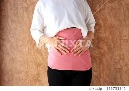 冷え性対策で腹巻きをする女性 温活イメージ 冷え性対策で腹巻きをする女性 温活イメージ 136753342