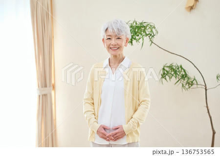 部屋で笑顔で立つアジア人シニア女性 部屋で笑顔で立つアジア人シニア女性 136753565