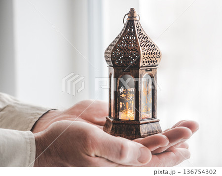 Man's hands hold a traditional Ramadan lantern Man's hands hold a traditional Ramadan lantern 136754302