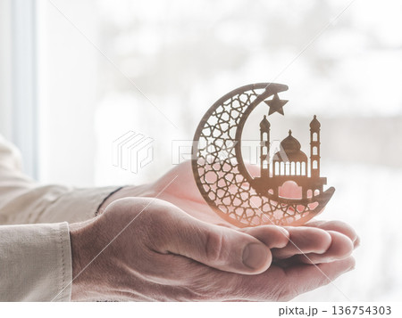 Man's hands holding crescent moon with mosque and star Man's hands holding crescent moon with mosque and star 136754303