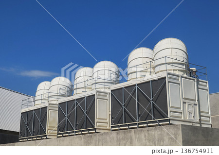 Large air conditioning compressor chiller unit on commercial building rooftop, HVAC cooling system equipment installation, industrial ventilation technology for climate control in urban architecture. Large air conditioning compressor chiller unit on commercial building rooftop, HVAC cooling system equipment installation, industrial ventilation technology for climate control in urban architecture. 136754911