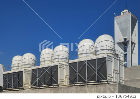 Large air conditioning compressor chiller unit on commercial building rooftop, HVAC cooling system equipment installation, industrial ventilation technology for climate control in urban architecture. 136754912