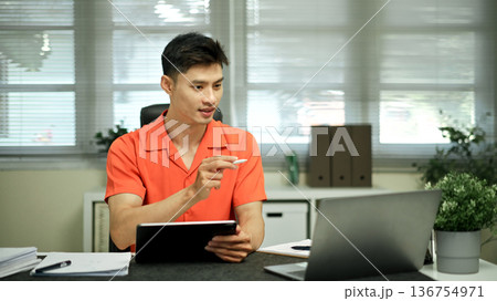 Asian man using digital tablet with stylus pen in the office Asian man using digital tablet with stylus pen in the office 136754971