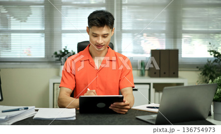 Asian man using digital tablet with stylus pen in the office 136754973