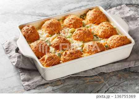 Chicken and Biscuit Casserole made with tender shredded chicken, creamy sauce, and topped with fluffy biscuits closeup on the baking dish. Horizontal Chicken and Biscuit Casserole made with tender shredded chicken, creamy sauce, and topped with fluffy biscuits closeup on the baking dish. Horizontal 136755369