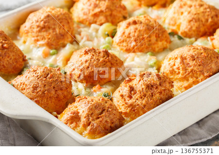 Close-up of chicken casserole with cheese biscuits, vegetables, and chicken soup in a baking dish. Horizontal Close-up of chicken casserole with cheese biscuits, vegetables, and chicken soup in a baking dish. Horizontal 136755371